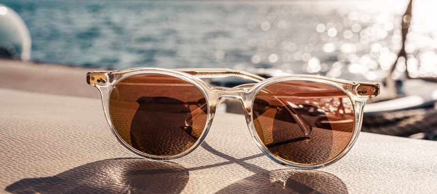tinted sunglasses in foreground with water in the background
