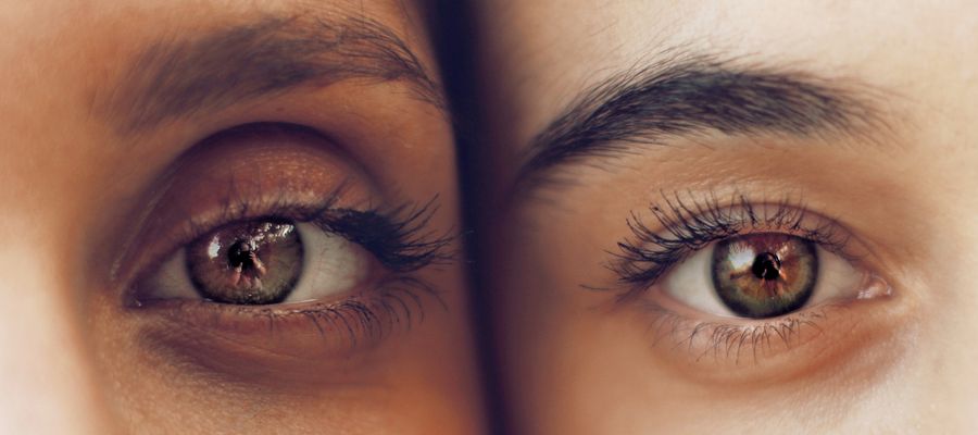 closeup of two eyes as two people hold their faces side by side