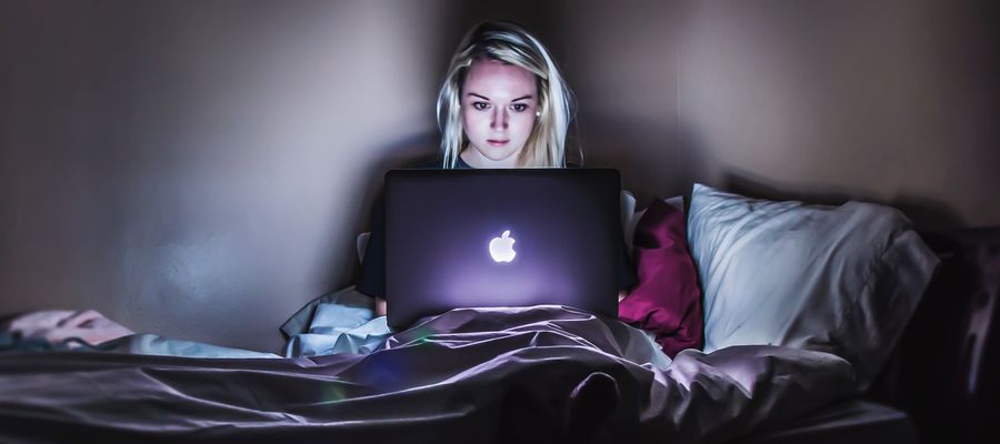 Woman using laptop late at night in bed